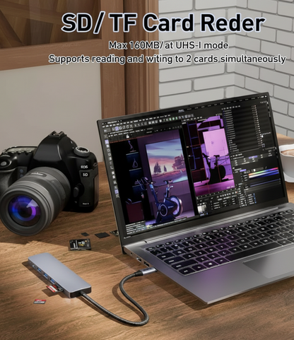 Laptop with SD/TF card reader on a desk next to a camera and coffee cup.