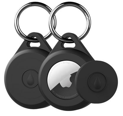 Two black circular key finder tags with metal key rings, shown on a plain white background. One tag is facing forward with a black center and a small droplet icon, while the other is angled to show a silver reflective back with a partially visible Apple logo and small text.